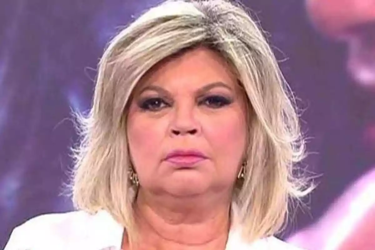 Mujer rubia de cabello corto y expresión seria en un estudio de televisión