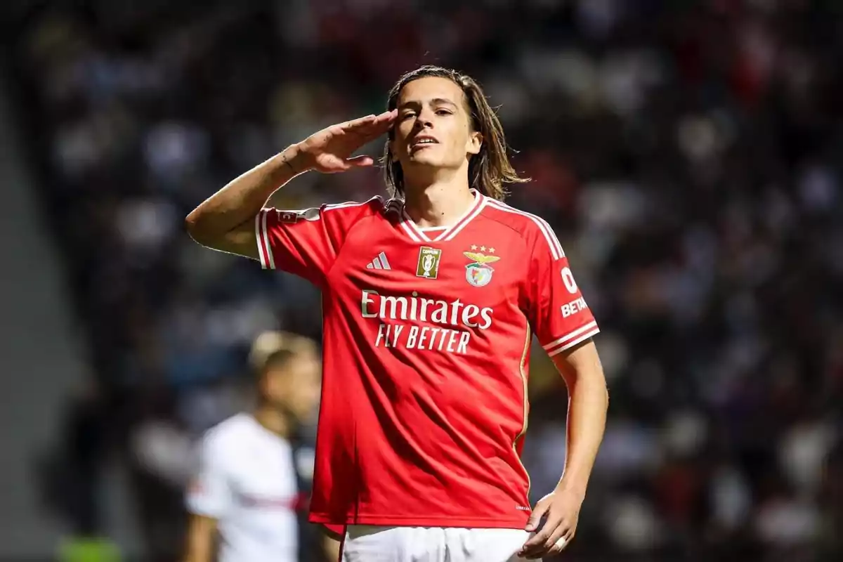 soccer player in a red Benfica jersey making a greeting gesture on the field. soccer player in a red Benfica jersey making a greeting gesture on the field.