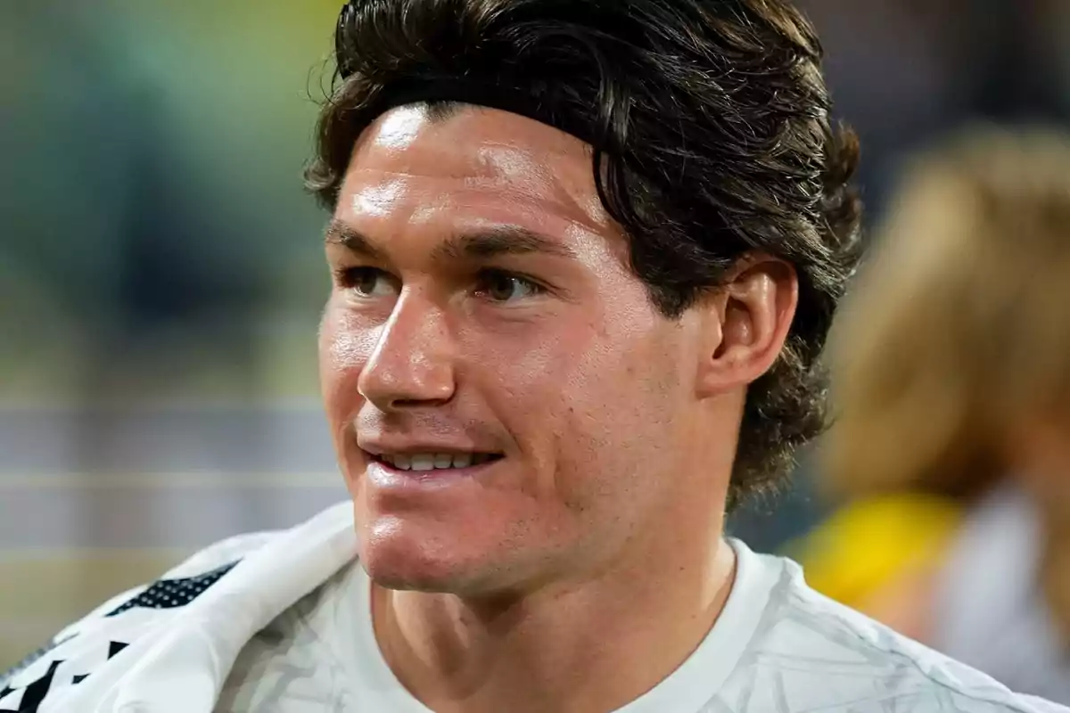 A man with dark hair and a headband, smiling and looking to the right. A man with dark hair and a headband, smiling and looking to the right.