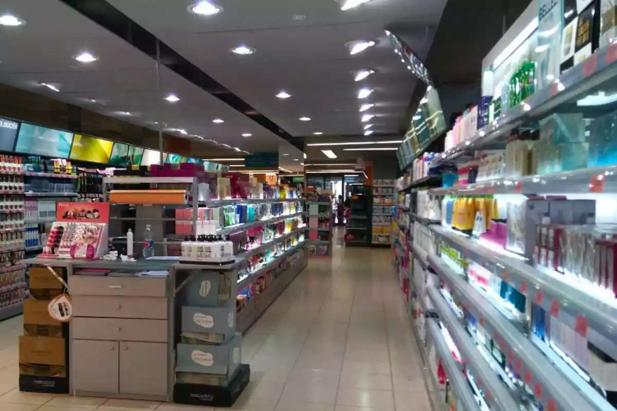 Passadís d'una botiga de Mercadona amb prestatges plens de productes de bellesa i cura personal il·luminats per llums al sostre. Passadís d'una botiga de Mercadona amb prestatges plens de productes de bellesa i cura personal il·luminats per llums al sostre.