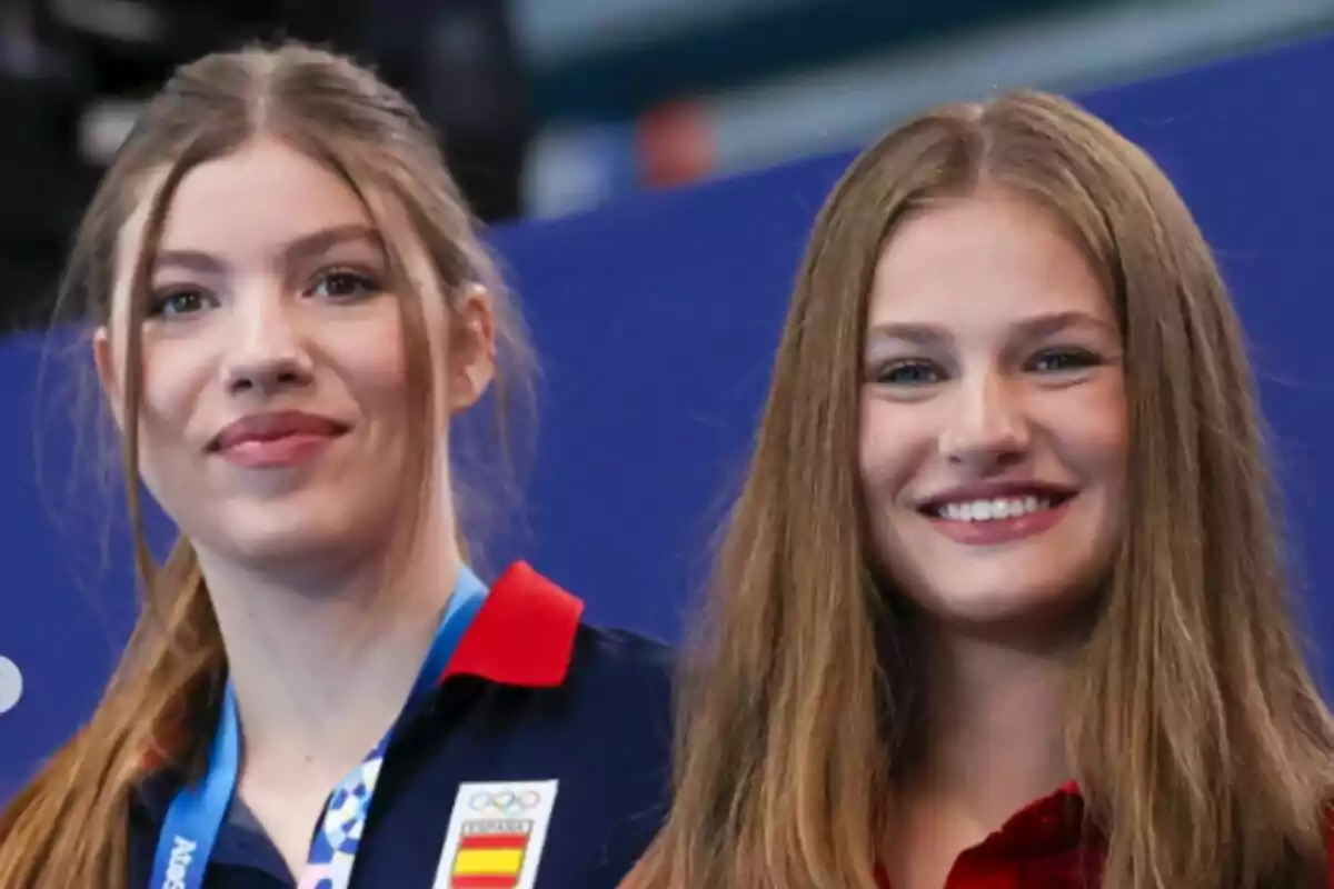 Two smiling young women, one of them wearing a medal and a uniform with the coat of arms of Spain. Two smiling young women, one of them wearing a medal and a uniform with the coat of arms of Spain.