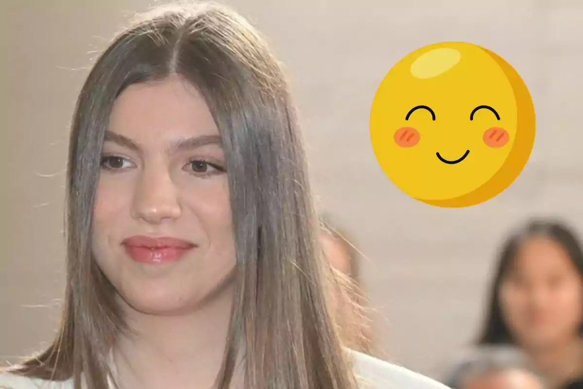 Infanta Sofía smiles slightly as a smiling emoji appears next to her. Infanta Sofía smiles slightly as a smiling emoji appears next to her.