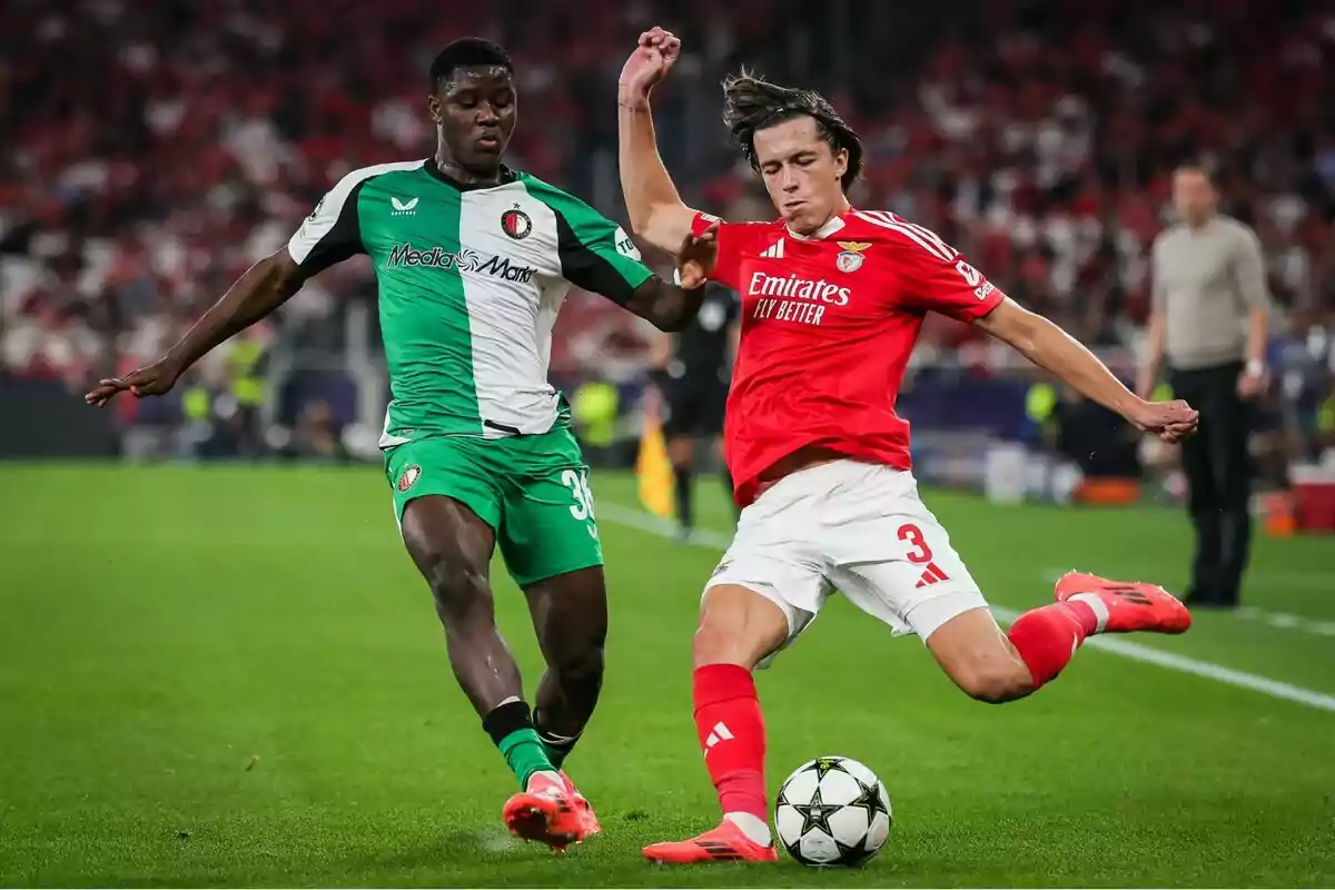 Two players compete for the ball in a match, one wearing a green and white uniform and the other red. Two players compete for the ball in a match, one wearing a green and white uniform and the other red.