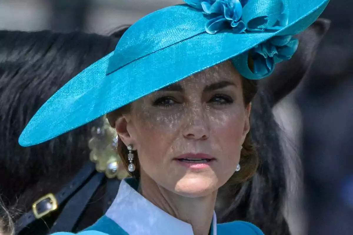Mujer con sombrero azul decorado con flores y pendientes de perla, con fondo desenfocado donde se distingue parte de un caballo negro