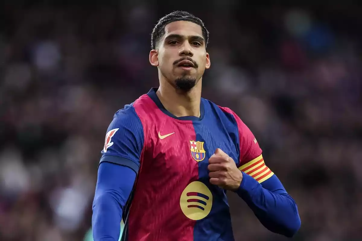 Un jugador de fútbol con uniforme azul y rojo en el campo.